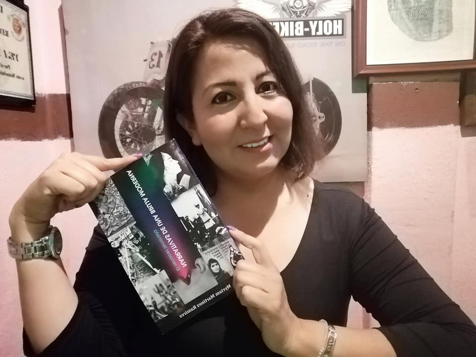 Myriam Martínez Ramírez mostrando su libro Narrativas de una Bruja Moderna